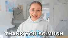 a girl in a grey hoodie is smiling and says thank you so much