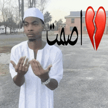 a man praying in front of a broken heart with arabic writing
