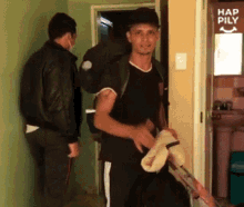a man carrying a backpack stands in front of a door that says hap pily
