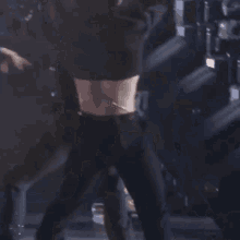 a woman in a black crop top is standing on a stage .