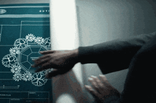 a person touching a blueprint that says outi on it