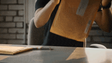 a person is holding a brown envelope with a white sticker on it that says ' a ' on it