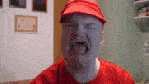 a bald man wearing a red hat and a red shirt is crying