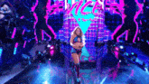 a woman is walking on a stage with a neon sign that says vice .
