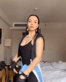 a woman is dancing in a room with a bed .