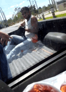 a man sitting in the back of a truck with a nike shirt on