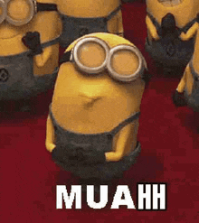 a group of minions are standing next to each other on a red carpet . one of the minions is wearing goggles .