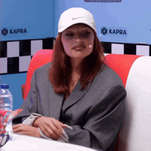 a woman wearing a white nike hat is sitting in a diner
