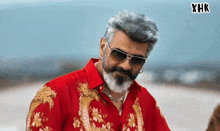 a man wearing sunglasses and a red shirt has the letters xhk on the bottom