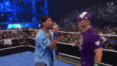 a man in a blue shirt with a motorola logo on it stands next to another man in a purple shirt