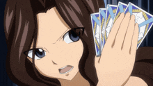 a woman is holding a bunch of playing cards in her hands
