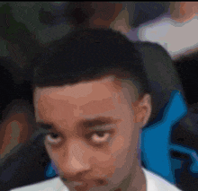 a blurry picture of a man 's face with a blue chair behind him