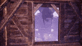 a monster is looking out of a window in a wooden building