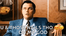 a man in a suit and tie is sitting on a couch and saying u & those nails tho oh my god