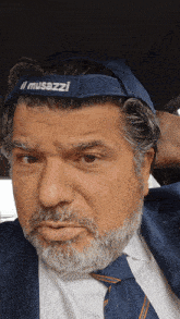 a man with a beard wears a blue headband that says musazzi