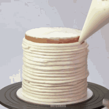 a cake is being frosted with white frosting and the word mr.cakes is on the bottom