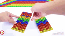 a person is playing with a rainbow colored toy made by animonica