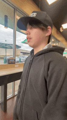 a young man wearing a black hat with rs on it