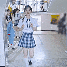 a girl in a plaid skirt and white socks is running down a hallway