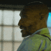 a bald man with a beard wearing a light blue shirt