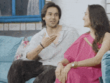 a man and a woman are sitting on a couch and talking