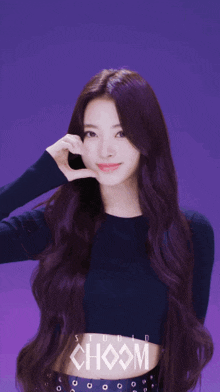 a girl with purple hair is wearing a black crop top with choom written on it
