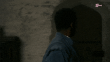 a man in a blue jacket stands in front of a wall and says nope