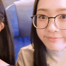 a close up of a woman wearing glasses looking at the camera