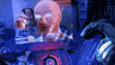 a computer screen shows a bald man with glasses and a microphone talking to another man .