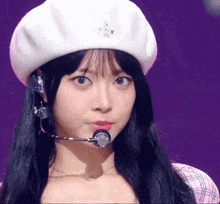 a girl wearing a white hat and a microphone looks at the camera