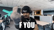 a man wearing headphones and a beanie says " f you "