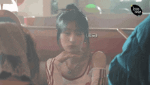 a woman sitting in a diner with a sign that says love this