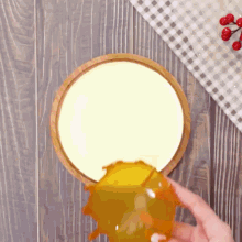 a person is pouring orange juice into a bowl of food