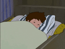 a boy is laying in bed with a striped pillow