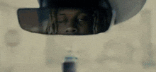 a man is looking at himself in a rear view mirror .