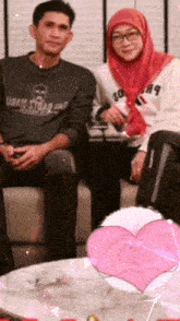 a man and a woman are sitting on a couch and the man is wearing a shirt that says urban star