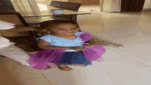 a little girl in a blue and purple dress