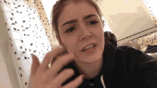 a woman is talking on a cell phone and making a face