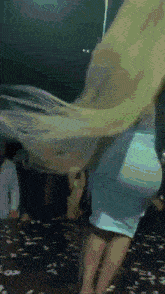 a woman in a blue dress is dancing on a stage