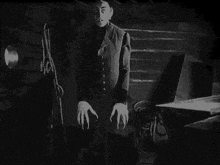a black and white photo of a vampire with long claws .