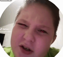 a close up of a person 's face in a circle with red eyes .