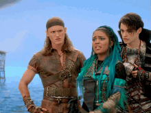 a woman with blue hair stands next to two men
