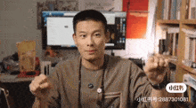 a man is sitting in front of a computer and a bookshelf with the number 28887301081 on the bottom