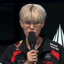 a man holding a microphone with a red bull logo on his jacket