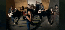a group of people are playing instruments in a room with a tama drum set in the background
