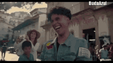 a man in a blue jacket is laughing while a woman takes a picture of him .