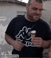 a man in a kappa shirt is holding a ice cream cone