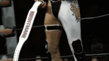 a wrestler is wearing a white belt with the word nightmare on it