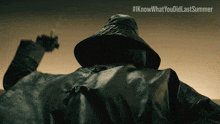 a person wearing a hat and a coat with the hashtag #iknowwhatyou didlastsummer on the bottom