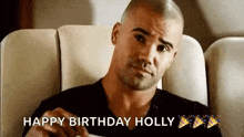 a man is sitting in a chair on a plane holding a piece of paper and a birthday cake .